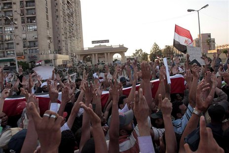 Supporters of deposed Egyptian President Mohamed Mursi carry mock coffins during a symbolic funeral for the four men killed during clashes w Supporters of deposed Egyptian President Mohamed Mursi carry mock coffins during a symbolic funeral for the four men killed during clashes w