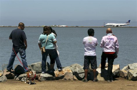 People look from a path along San Francisco Bay after an Asiana Airlines Boeing 777 that crashed while landing at San Francisco Internationa People look from a path along San Francisco Bay after an Asiana Airlines Boeing 777 that crashed while landing at San Francisco Internationa