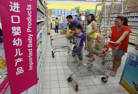 A family looks at foreign imported milk powder products at a supermarket in Beijing July 3, 2013. REUTERS/Kim Kyung-Hoon A family looks at foreign imported milk powder products at a supermarket in Beijing July 3, 2013. REUTERS/Kim Kyung-Hoon