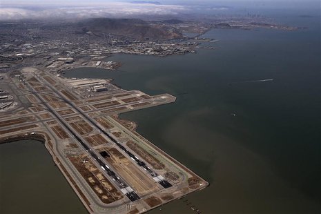The San Francisco skyline is seen in the background as an Asiana Airlines Boeing 777 plane lies off the runway after it crashed while landin The San Francisco skyline is seen in the background as an Asiana Airlines Boeing 777 plane lies off the runway after it crashed while landin