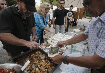 Constantinos Polychronopoulos (L), from the group called "O Allos Anthropos", or "The Fellow Man", distributes food portions at a soup kitch Constantinos Polychronopoulos (L), from the group called "O Allos Anthropos", or "The Fellow Man", distributes food portions at a soup kitch