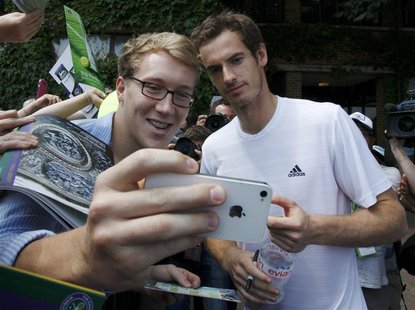 Andy Murray of Britain has a photograph taken by a fan at the Wimbledon Tennis Championships, in London July 6, 2013. REUTERS/Suzanne Plunke Andy Murray of Britain has a photograph taken by a fan at the Wimbledon Tennis Championships, in London July 6, 2013. REUTERS/Suzanne Plunke