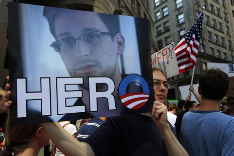 A demonstrator holds a sign with a photograph of former U.S. spy agency NSA contractor Edward Snowden and the word "HERO" during Fourth of J A demonstrator holds a sign with a photograph of former U.S. spy agency NSA contractor Edward Snowden and the word "HERO" during Fourth of J