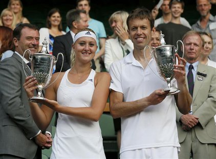 Daniel Nestor (R) of Canada and Kristina Mladenovic of France hold their winners trophies after defeating Bruno Soares of Brazil and Lisa Ra Daniel Nestor (R) of Canada and Kristina Mladenovic of France hold their winners trophies after defeating Bruno Soares of Brazil and Lisa Ra