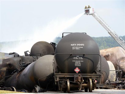Firefighters spray water on the wreckage of the train explosion in Lac Megantic, July 7, 2013. REUTERS/Paul Chiasson/Pool Firefighters spray water on the wreckage of the train explosion in Lac Megantic, July 7, 2013. REUTERS/Paul Chiasson/Pool