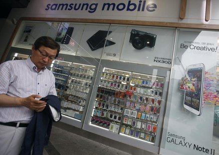 A man uses his mobile phone in front of a Samsung mobile shop in Seoul July 4, 2013. REUTERS/Kim Hong-Ji A man uses his mobile phone in front of a Samsung mobile shop in Seoul July 4, 2013. REUTERS/Kim Hong-Ji