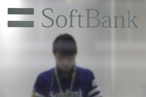 A shop clerk is seen through a window displaying a logo of SoftBank Corp at its branch in Tokyo June 21, 2013. REUTERS/Issei Kato A shop clerk is seen through a window displaying a logo of SoftBank Corp at its branch in Tokyo June 21, 2013. REUTERS/Issei Kato