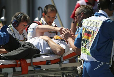 A cameraman is carried on a stretcher after being injured by a lost rear tyre of Red Bull Formula One driver Mark Webber of Australia during A cameraman is carried on a stretcher after being injured by a lost rear tyre of Red Bull Formula One driver Mark Webber of Australia during