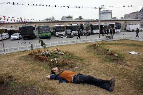 A Gezi Park demonstrator sleeps in front of riot police vehicles at Taksim Square in Istanbul June 14, 2013. REUTERS/Murad Sezer A Gezi Park demonstrator sleeps in front of riot police vehicles at Taksim Square in Istanbul June 14, 2013. REUTERS/Murad Sezer