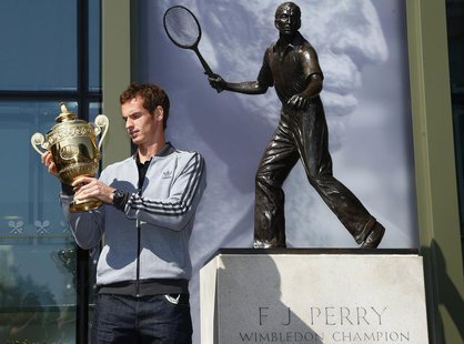 Tennis player Andy Murray of Britain holds the trophy under a statue of former British champion Fred Perry, at Wimbledon, southwest London J Tennis player Andy Murray of Britain holds the trophy under a statue of former British champion Fred Perry, at Wimbledon, southwest London J