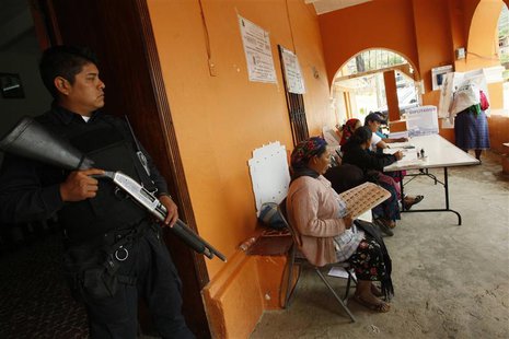 A police officer stands guard at a polling station in San Bartolome Quialana, in the outskirts of Oaxaca, July 7, 2013. REUTERS/Jorge Luis P A police officer stands guard at a polling station in San Bartolome Quialana, in the outskirts of Oaxaca, July 7, 2013. REUTERS/Jorge Luis P