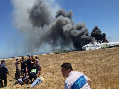 First responders tend to Asiana Airlines flight attendants and rescued passengers as they gather near the runway after flight 214 crash land First responders tend to Asiana Airlines flight attendants and rescued passengers as they gather near the runway after flight 214 crash land