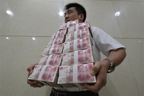 An employee carries bundles of 100 yuan Chinese bank notes to store after counting at a bank in Taiyuan, Shanxi province July 4, 2013. REUTE An employee carries bundles of 100 yuan Chinese bank notes to store after counting at a bank in Taiyuan, Shanxi province July 4, 2013. REUTE