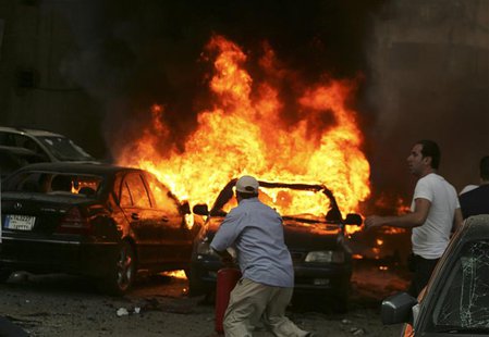 Men try to extinguish fire from burning cars at the site of an explosion, in Beirut's southern suburbs, July 9, 2013. REUTERS/Issam Kobeisy Men try to extinguish fire from burning cars at the site of an explosion, in Beirut's southern suburbs, July 9, 2013. REUTERS/Issam Kobeisy