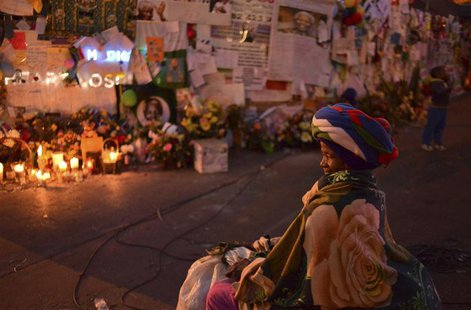 A traditionally clad woman sits in front of messages of support posted outside the Pretoria Medi-clinic Heart hospital where former Presiden A traditionally clad woman sits in front of messages of support posted outside the Pretoria Medi-clinic Heart hospital where former Presiden