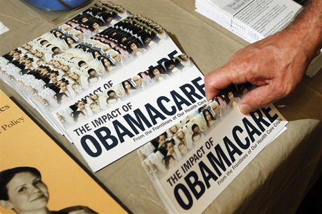 A Tea Party member reaches for a pamphlet titled "The Impact of Obamacare", at a "Food for Free Minds Tea Party Rally" in Littleton, New Ham A Tea Party member reaches for a pamphlet titled "The Impact of Obamacare", at a "Food for Free Minds Tea Party Rally" in Littleton, New Ham