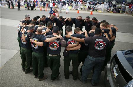 Firefighters pray in front of a memorial dedicated to the 19 firefighters killed in the nearby wildfire in Prescott, Arizona, July 8, 2013.
REUTERS/Lucy Nicholson Firefighters pray in front of a memorial dedicated to the 19 firefighters killed in the nearby wildfire in Prescott, Arizona, July 8, 2013.
REUTERS/Lucy Nicholson