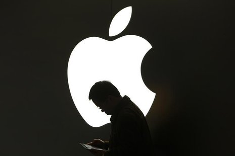 A man looks at his Apple iPad in front an Apple logo outside an Apple store in downtown Shanghai March 16, 2012. REUTERS/Aly Song A man looks at his Apple iPad in front an Apple logo outside an Apple store in downtown Shanghai March 16, 2012. REUTERS/Aly Song