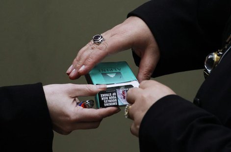 Women handle a cigarette pack in central Sydney October 12, 2011. REUTERS/Daniel Munoz Women handle a cigarette pack in central Sydney October 12, 2011. REUTERS/Daniel Munoz