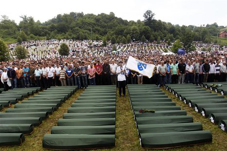 Bosnians pray in front of 409 coffins of newly identified victims of the 1995 Srebrenica massacre in the Potocari Memorial Center, near Sreb Bosnians pray in front of 409 coffins of newly identified victims of the 1995 Srebrenica massacre in the Potocari Memorial Center, near Sreb