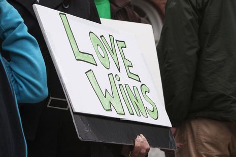 A mourner holds a placard as residents gather outside the town hall to observe the six-month anniversary of the massacre at Sandy Hook Eleme A mourner holds a placard as residents gather outside the town hall to observe the six-month anniversary of the massacre at Sandy Hook Eleme
