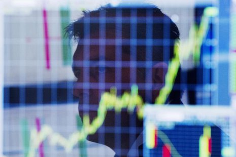 A trader looks up at a chart on his computer screen while working on the floor of the New York Stock Exchange shortly after the market openi A trader looks up at a chart on his computer screen while working on the floor of the New York Stock Exchange shortly after the market openi