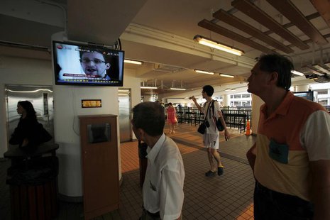 Passengers watch news footage of Edward Snowden before getting aboard a Star Ferry to cross Hong Kong's Victoria Harbour July 12, 2013. REUT Passengers watch news footage of Edward Snowden before getting aboard a Star Ferry to cross Hong Kong's Victoria Harbour July 12, 2013. REUT