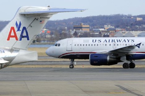A US Airways plane (R) taxis for takeoff past an American Airlines plane at the Ronald Reagan Washington National Airport in Arlington Count A US Airways plane (R) taxis for takeoff past an American Airlines plane at the Ronald Reagan Washington National Airport in Arlington Count