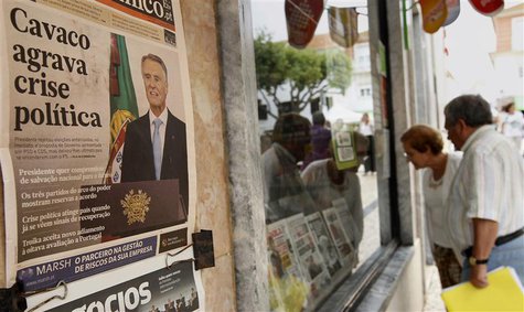 People look at the front pages of newspapers displayed behind the window of a shop in Ericeira village, 40 km (24 miles) north of Lisbon Jul People look at the front pages of newspapers displayed behind the window of a shop in Ericeira village, 40 km (24 miles) north of Lisbon Jul
