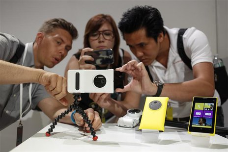 Guests at Nokia's unveiling of its new Lumia 1020 smartphone use the new phone's 41-megapixel camera with a grip in New York July 11, 2013. Guests at Nokia's unveiling of its new Lumia 1020 smartphone use the new phone's 41-megapixel camera with a grip in New York July 11, 2013.