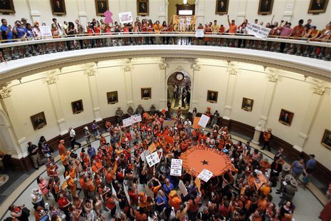 Abortion rights (in orange) and anti-abortion advocates (in blue) rally in the rotunda of the State Capitol, as the state Senate meets to co Abortion rights (in orange) and anti-abortion advocates (in blue) rally in the rotunda of the State Capitol, as the state Senate meets to co