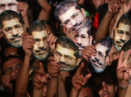 Members of the Muslim Brotherhood and supporters of deposed Egyptian President Mohamed Mursi hold up masks of him as they gather at the Raba Members of the Muslim Brotherhood and supporters of deposed Egyptian President Mohamed Mursi hold up masks of him as they gather at the Raba