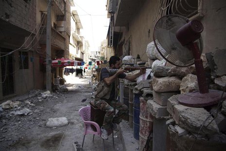 A Free Syrian Army fighter points his weapon as he takes up position behind sandbags in Deir al-Zor July 13, 2013. REUTERS/Khalil Ashawi A Free Syrian Army fighter points his weapon as he takes up position behind sandbags in Deir al-Zor July 13, 2013. REUTERS/Khalil Ashawi