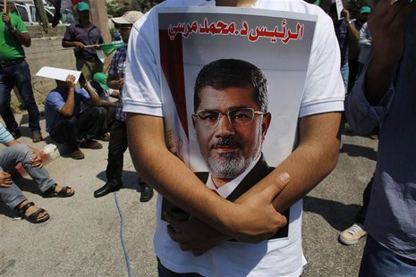 An Israeli Arab man holds a picture of the deposed Egyptian President Mohamed Mursi during a demonstration in support of him in the northern An Israeli Arab man holds a picture of the deposed Egyptian President Mohamed Mursi during a demonstration in support of him in the northern