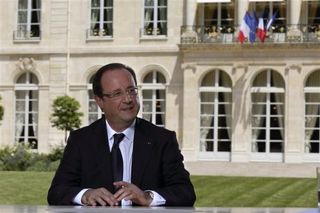 French President Francois Hollande speaks with journalists after a television interview in the garden of the Elysee Palace, following the tr French President Francois Hollande speaks with journalists after a television interview in the garden of the Elysee Palace, following the tr