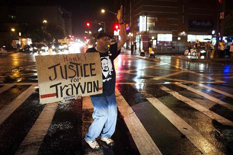 Will Reese holds a protest sign in response to the acquittal of George Zimmerman in the Trayvon Martin trial, in the Harlem neighborhood of Will Reese holds a protest sign in response to the acquittal of George Zimmerman in the Trayvon Martin trial, in the Harlem neighborhood of