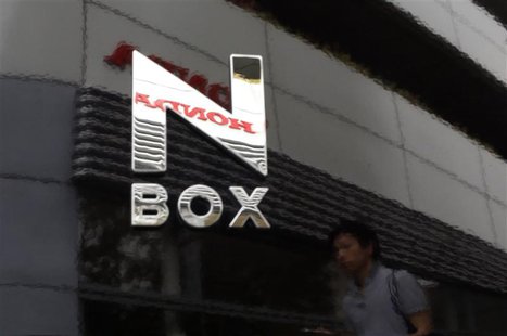 The logo of Honda Motor Co and a passer-by are reflected on a Honda N Box minicar outside the company's showroom in Tokyo July 13, 2013. REU The logo of Honda Motor Co and a passer-by are reflected on a Honda N Box minicar outside the company's showroom in Tokyo July 13, 2013. REU
