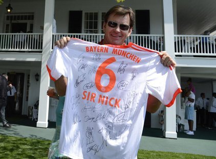 Former champion Nick Faldo of England holds up an autographed sweater from Bayern Munich that was presented to him before a practice round i Former champion Nick Faldo of England holds up an autographed sweater from Bayern Munich that was presented to him before a practice round i