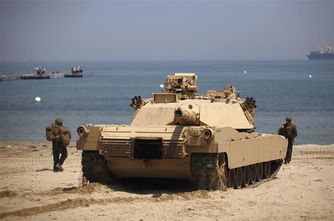 A U.S. marine soldier directs a M1A1 battle tank during the Combined Joint Logistics Over The Shore (CJLOTS) exercise, as a part of the annu A U.S. marine soldier directs a M1A1 battle tank during the Combined Joint Logistics Over The Shore (CJLOTS) exercise, as a part of the annu