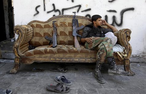 A Free Syrian Army fighter sits on a sofa in the old city of Aleppo, July 3, 2013. REUTERS/Muzaffar Salman A Free Syrian Army fighter sits on a sofa in the old city of Aleppo, July 3, 2013. REUTERS/Muzaffar Salman