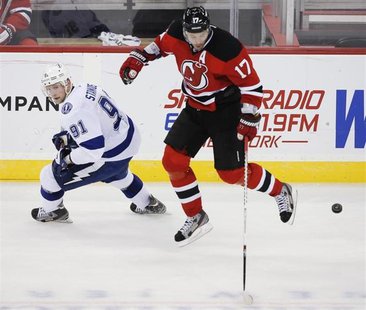 New Jersey Devils right wing Ilya Kovalchuk (17) leaps over the puck in front of Tampa Bay Lightning center Steven Stamkos (91) in the third New Jersey Devils right wing Ilya Kovalchuk (17) leaps over the puck in front of Tampa Bay Lightning center Steven Stamkos (91) in the third