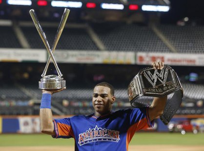 American League batter Yoenis Cespedes, of the Oakland A's, holds up the Home Run trophy and a belt after winning the Major League Baseball American League batter Yoenis Cespedes, of the Oakland A's, holds up the Home Run trophy and a belt after winning the Major League Baseball
