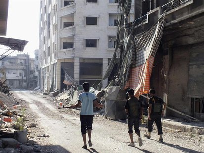 Members of the Free Syrian Army walk along a damaged street filled with debris in the besieged area of Homs July 13, 2013. REUTERS/Yazan Hom Members of the Free Syrian Army walk along a damaged street filled with debris in the besieged area of Homs July 13, 2013. REUTERS/Yazan Hom
