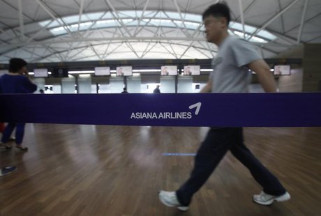 A passenger walks past a logo of Asiana Airline at the Incheon Airport in Incheon, west of Seoul July 7, 2013. REUTERS/Kim Hong-Ji A passenger walks past a logo of Asiana Airline at the Incheon Airport in Incheon, west of Seoul July 7, 2013. REUTERS/Kim Hong-Ji
