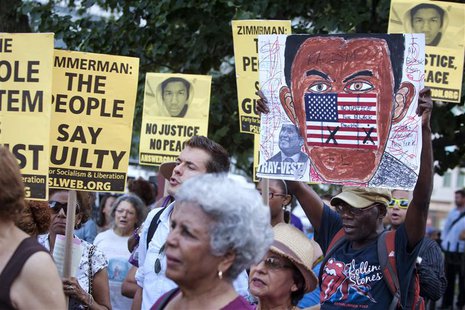 People attend a vigil for slain youth Trayvon Martin, as well as to protest the acquittal of George Zimmerman for the shooting death of Mart People attend a vigil for slain youth Trayvon Martin, as well as to protest the acquittal of George Zimmerman for the shooting death of Mart