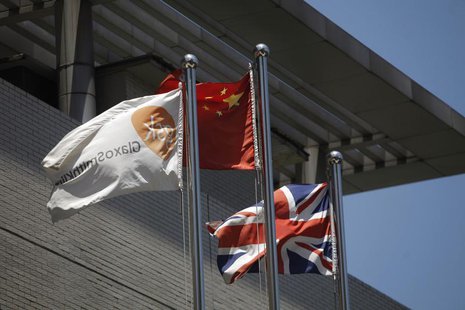 A flag (L) bearing the logo of GlaxoSmithKline (GSK) flutters next to a Chinese national flag (C) and a Union Flag (R), outside a GlaxoSmith A flag (L) bearing the logo of GlaxoSmithKline (GSK) flutters next to a Chinese national flag (C) and a Union Flag (R), outside a GlaxoSmith