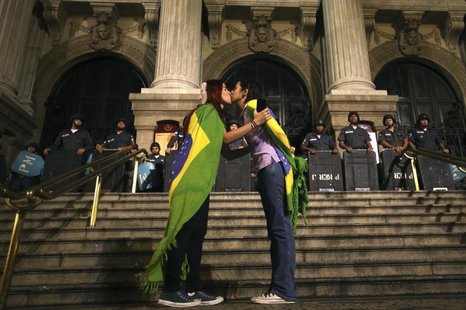 Two demonstrators kiss each other in front of police officers during a protest in central Rio de Janeiro June 27, 2013. REUTERS/Pilar Olivar Two demonstrators kiss each other in front of police officers during a protest in central Rio de Janeiro June 27, 2013. REUTERS/Pilar Olivar