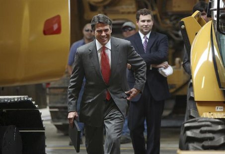Texas governor Rick Perry walks to the stage in between heavy equipment at Holt Cat to announce he is not running for re-election as governo Texas governor Rick Perry walks to the stage in between heavy equipment at Holt Cat to announce he is not running for re-election as governo