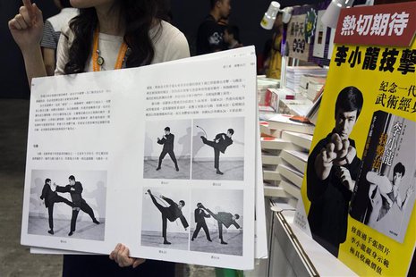 A shopkeeper introduces a latest Chinese edition of "Bruce Lee's Fighting Method" by the late Kung Fu legend Bruce Lee on the first day of t A shopkeeper introduces a latest Chinese edition of "Bruce Lee's Fighting Method" by the late Kung Fu legend Bruce Lee on the first day of t