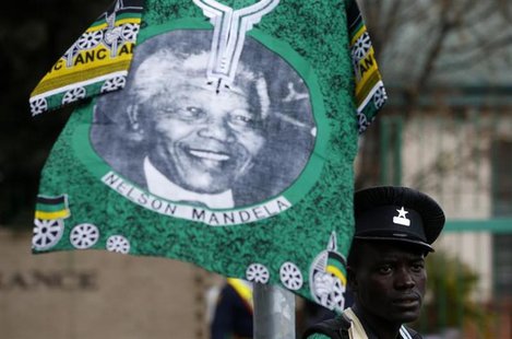 A street photographer stands beneath a shirt hanging outside the hospital where ailing former President Nelson Mandela is being treated in P A street photographer stands beneath a shirt hanging outside the hospital where ailing former President Nelson Mandela is being treated in P